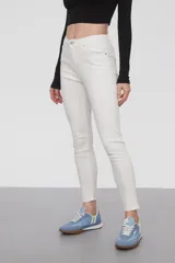 Pantalon jean de corte skinny y tiro medio, en color blanco, con cierre frontal y bolsillos laterales.