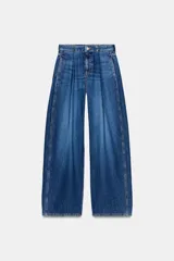 Jeans de tiro alto con corte loose fit y pernera holgada. Presenta detalle de corchetes en la cintura, bolsillos frontales y bolsillos de plastrón en la parte trasera. Cierre frontal con cremallera y botón.