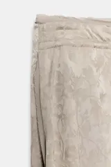 Pantalón de tiro medio de ZARA WOMAN COLLECTION, confeccionado en hilatura de viscosa con tejido jacquard de estampado floral sutil en tono beige. Presenta pierna ancha, acabado en pliegue y cintura ajustable con cordón de lazada.