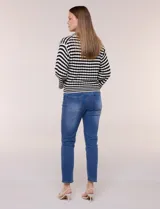 Blusa tejida de punto a rayas horizontales blancas y negras, con cuello polo y escote en V profundo. Presenta hombros caídos, mangas 3/4 estilo campana y corte holgado.