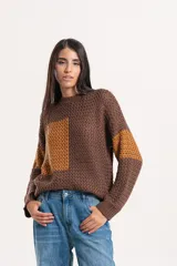 Buzo de tejido de punto con diseño combinado en tonos marrón y ocre, de cuello redondo y manga larga.