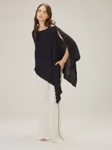 Chal de punto acanalado negro con fibra metalizada, de diseño asimétrico y caída fluida.