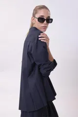 Camisa blanca de corte oversize, con cuello clásico y mangas largas con puños abotonados.