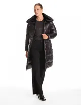 Campera puffer larga de acabado satinado en color beige. Presenta un diseño capitoneado horizontal, cuello amplio revestido en piel sintética, cierre frontal bidireccional y bolsillos laterales con cremallera.