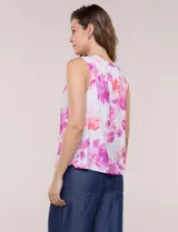 Blusa sin mangas de viscosa blanca con estampado floral en tonos azules, cuello redondo y cierre frontal parcial con botones.