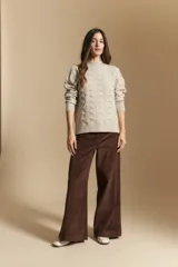 Sweater de punto color beige con diseño geométrico en relieve, cuello alto y mangas largas con puños acanalados.
