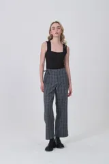 Pantalón de poliéster con estampado tartán en tonos grises y azules. Diseño de tiro medio, corte recto y ancho, con detalle de lazo ajustable en la cintura.