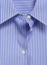 Camisa de corte recto con diseño de rayas verticales, cuello camisero clásico y cierre frontal con botones. Presenta mangas largas con puños abotonados.