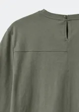 Blusa de manga corta color verde militar, con cuello redondo y diseño de paneles con costuras visibles.
