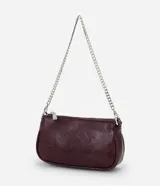 Cartera bandolera compacta de cuero sintético color negro, con cierre superior y doble correa de cadena metálica, una corta para el hombro y una larga ajustable.