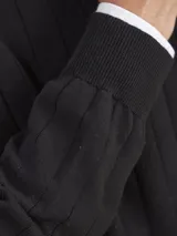 Sweater negro de algodón con cuello redondo y textura acanalada vertical.