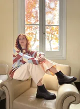 Sweater de punto con diseño geométrico en tonos celeste, marrón y beige.