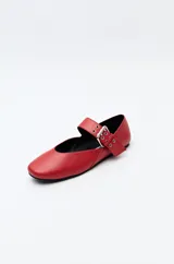 Balerina roja de cuero sintético con punta ligeramente afilada y tira ancha con hebilla metálica.