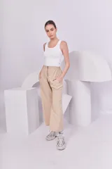 Pantalón recto color beige con cintura elástica y cierre metálico.