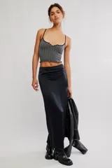 Top corto sin costuras de tejido acanalado y texturado color marfil, con escote redondo amplio, botonadura henley al frente con pequeños botones a presión, tiras finas fijas y terminación con ruedo en lechuga, de calce ajustado.