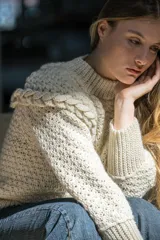 Sweater tejido a crochet color crudo, de lana merino, con cuello alto acanalado y trenza 3D simétrica en relieve en frente y espalda.