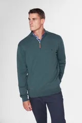 Buzo de tejido fino en hilo de algodón, color rosado, con cuello alto y cierre frontal parcial con detalle en cuero. Presenta puños y ruedo acanalados y un pequeño logo bordado en el pecho.