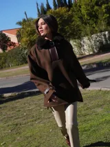 Buzo marrón con cuello de piel sintética, cierre parcial con hebilla y mangas largas con ajuste en los puños.