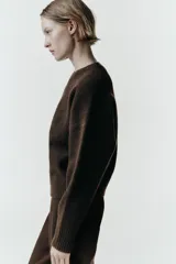 Jersey de cuello redondo y manga larga, confeccionado en tejido de punto suave con acabados en rib en cuello, puños y bajo.