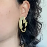 Par de aros colgantes plateados con forma irregular y cadena de eslabones.