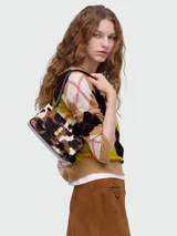 Bolso de hombro pequeño Marc Jacobs The Mini Dual Shoulder Bag, con textura de pelo animal print (leopardo/vaca) en tonos marrón, negro y beige. Presenta un cierre metálico dorado en la solapa y correa negra.