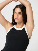 Musculosa deportiva con cuello halter, diseño bicolor en negro y blanco, confeccionada en tejido técnico elástico.