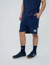 Bermuda deportiva Umbro de color azul marino, con inserciones laterales en color blanco y el logo de la marca estampado en la pierna izquierda.