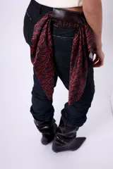 Pañuelo cuadrado de seda con estampado repetitivo de un diseño abstracto en rojo sobre fondo negro.