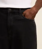 Pantalon de jean gris con lavado deslavado, de corte baggy y silueta holgada. Cuenta con bolsillos al frente y atras, y cierre de boton y cremallera.