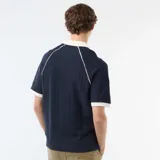 Remera de tejido de punto acanalado en color azul marino, con cuello polo en contraste color crema y detalles de ribeteado en las mangas y costuras raglán.