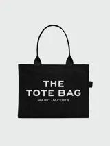 Bolso tipo tote de gran tamaño en color beige, confeccionado en lona resistente. Presenta el logo distintivo de la marca estampado en la parte frontal con letras blancas. Cuenta con doble asa superior para llevar al hombro y cierre superior con cremallera.