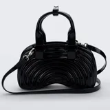 Cartera Melissa modelo Quantum Dome de material sintético brillante con acabado efecto charol, en color negro. Presenta un diseño estructurado de líneas curvas concéntricas, doble asa superior y correa ajustable y desmontable para llevar al hombro o cruzada. Cuenta con herrajes metálicos plateados.