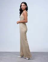 Enterito largo de gasa lurex plisada color dorado, con escote halter, cintura elastizada con punto smock, abertura en la espalda con cierre invisible y forro interno a tono.