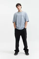 Remera marrón de manga corta con corte oversize y cuello redondo. Estampado en la espalda con diseño abstracto y texto.