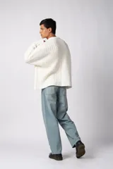 Sweater de punto color blanco con diseño de textura combinada, presentando un lado liso y otro con tejido trenzado. Posee cuello redondo, mangas largas y un corte relajado.