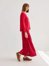 Falda larga de tejido liviano en color rojo, con corte recto y caída fluida. Presenta una textura suave y un diseño minimalista.