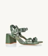 Sandalias de tacón color verde oliva, con tiras con apliques de tachas piramidales y hebilla metálica.