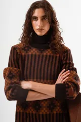 Sweater de cuello alto con diseño de tejido jacquard en tonos marrones y negros, con patrón geométrico y de rayas verticales, de manga larga con puños acanalados.