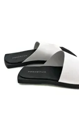 Sandalias de cuero color blanco con suela plana color negro.