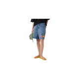 Short de denim color celeste con efecto desgastado, de tiro medio y corte recto. Cuenta con bolsillos clásicos y tres parches bordados decorativos en la parte inferior izquierda.