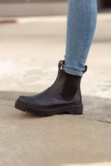 Bota chelsea negra de cuero con elásticos laterales y suela track.