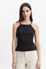 Musculosa verde militar con breteles finos cruzados en la espalda y escote recto.