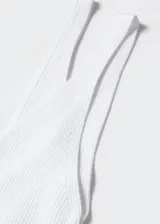 Top de punto fino con escote en pico y tirantes finos. Presenta un diseño entallado y espalda abierta.