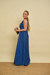 Vestido largo azul con textura arrugada, escote en V pronunciado, sin mangas y falda evasé.