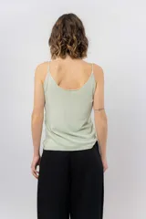 Musculosa de breteles finos con escote en V, confeccionada en tejido fluido con acabado satinado.