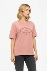 Remera de manga corta color rosado, con diseño holgado, cuello redondo a la base y estampa frontal en tono bordó con la inscripción "Saint Paradiso Italia Beach Club 1991".