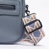 Bandolera de cuero sintético color celeste, con textura granulada, cierre frontal con tirador largo y correa ajustable con diseño geométrico en tonos beige y azul.