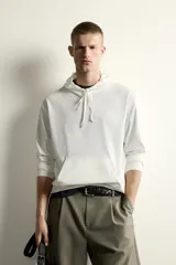 Hoodie ligero de corte regular fit color blanco, confeccionado en algodón, con capucha ajustable mediante cordón, mangas largas y bolsillo frontal tipo canguro.