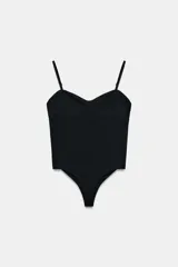 Body negro de corte ajustado, con escote corazón y ribete de encaje o festón en el borde superior. Posee tirantes finos ajustables y cierre de broches en la parte inferior.