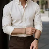 Camisa de algodón oxford color beige, con cuello americano button-down y mangas largas.